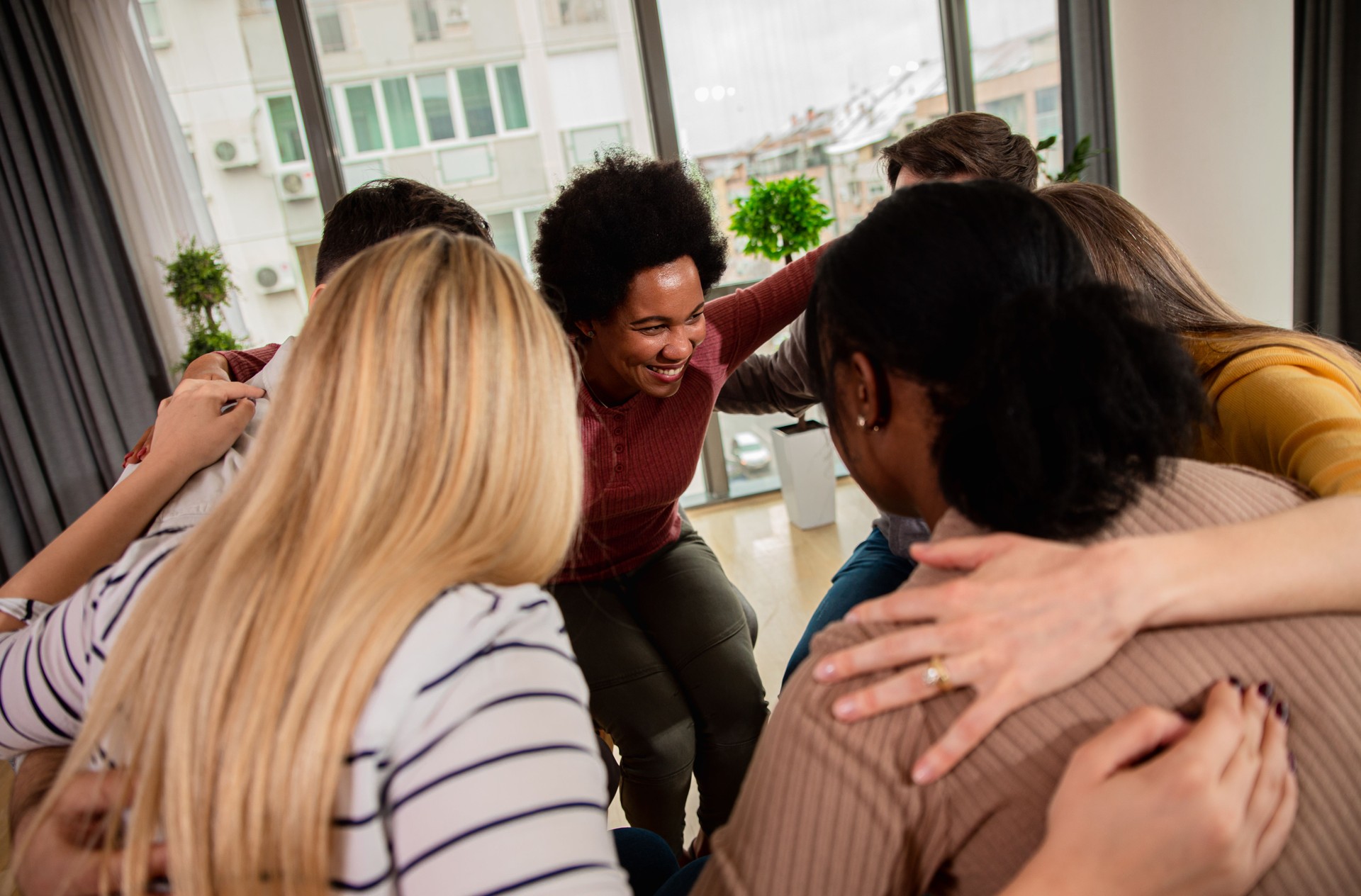 Diverse group of people sitting in circle in group therapy session.